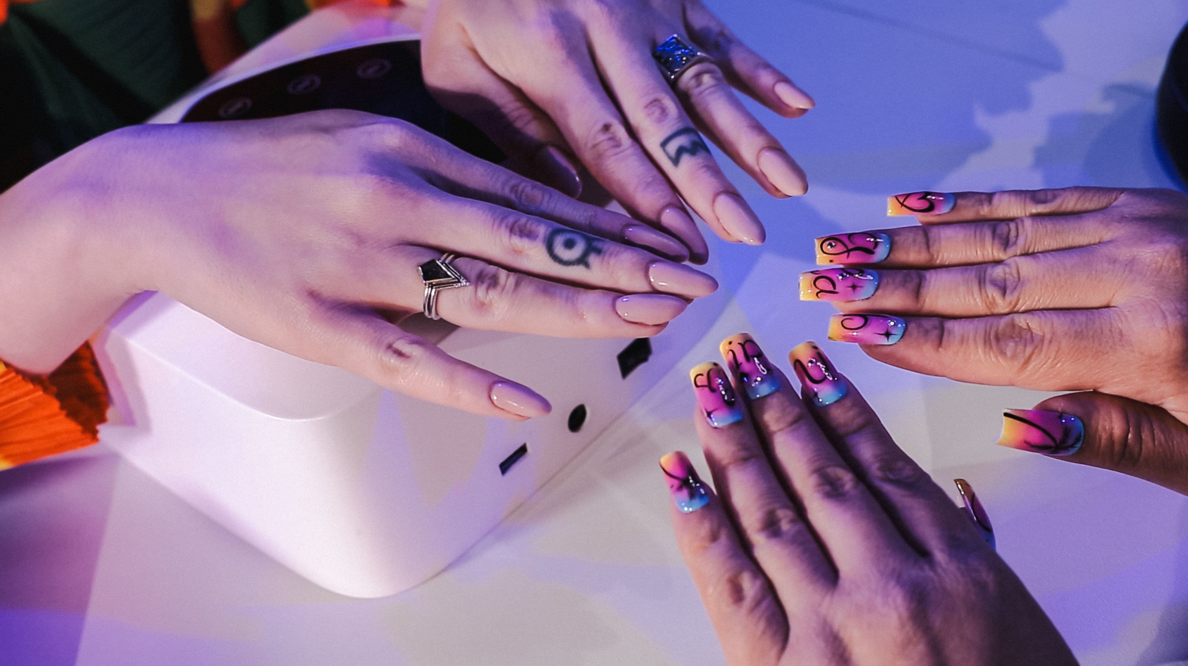 Two people show off their nails.