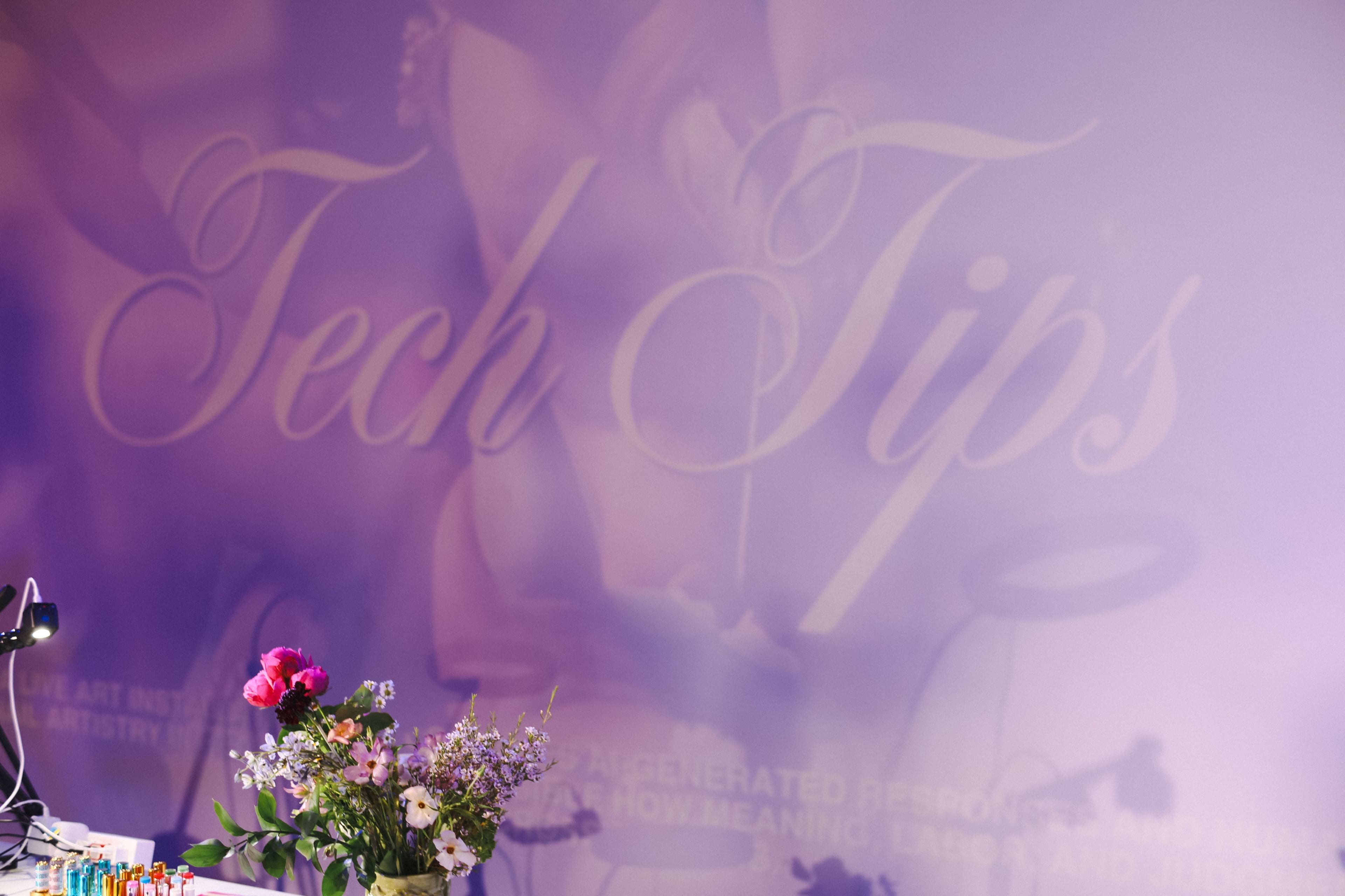A projection of the graphic title "Tech Tips" with a bouquet in front.