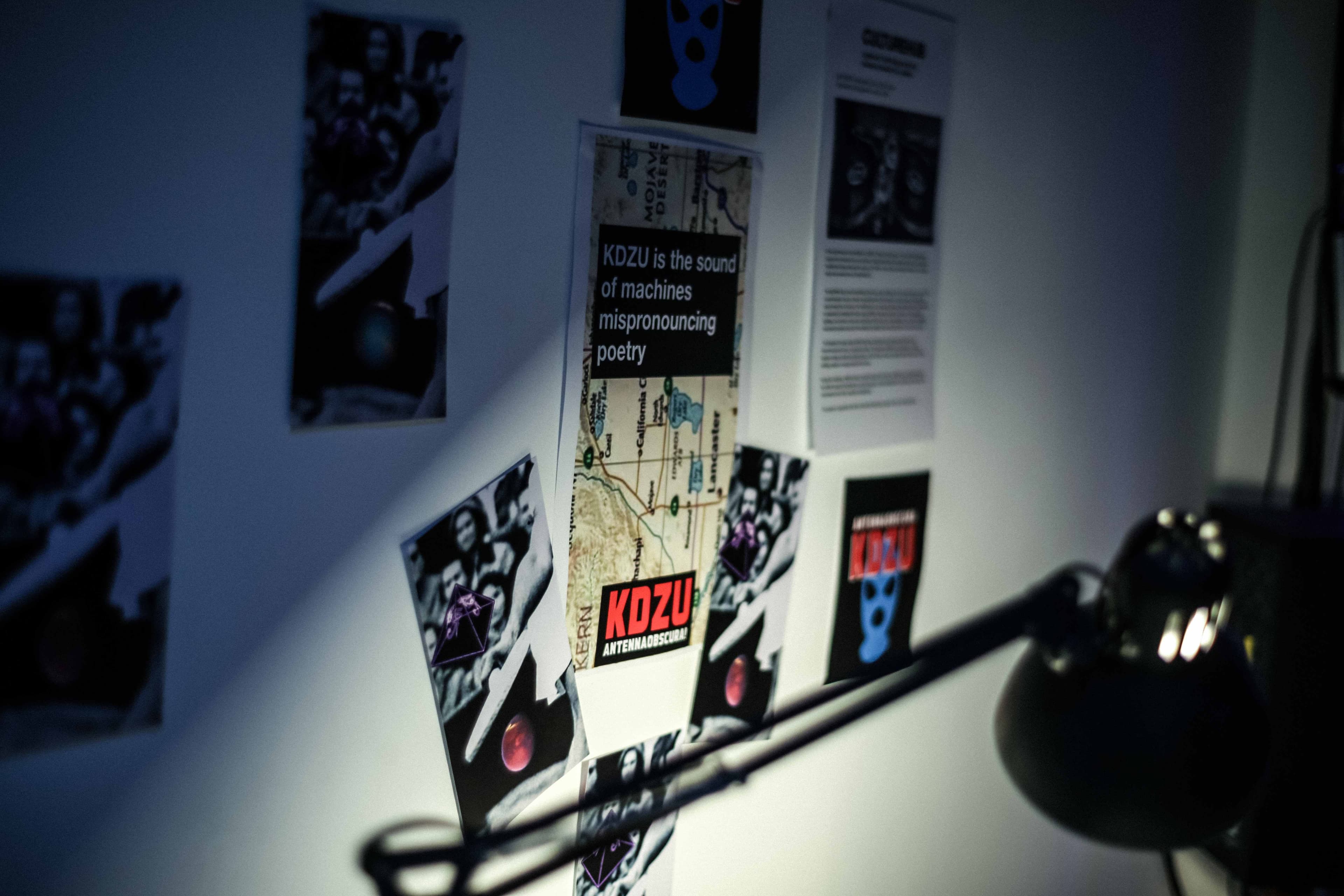 KDZU postcards on a white wall.