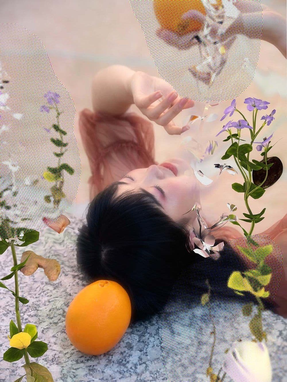 An asian woman lies on her back, near flowers and an unpeeled orange. Her right hand holds another orange, her left hand is held in front of her face. Portions of the image have been obscured with a dot matrix texture.